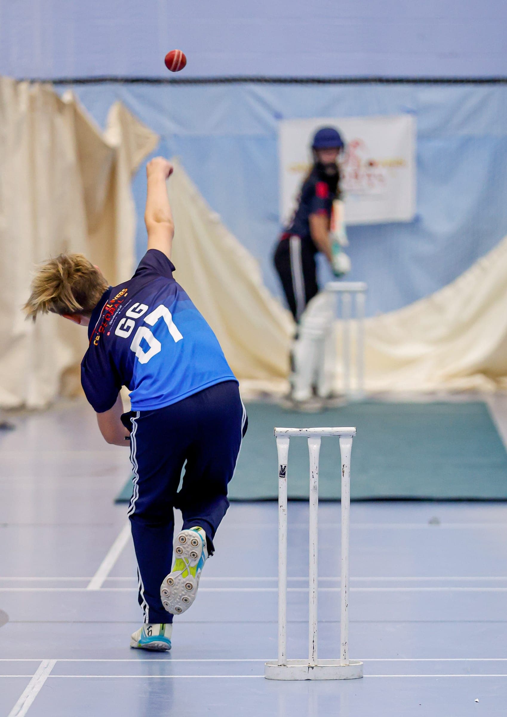 Bowler in delivery stride in indoor nets