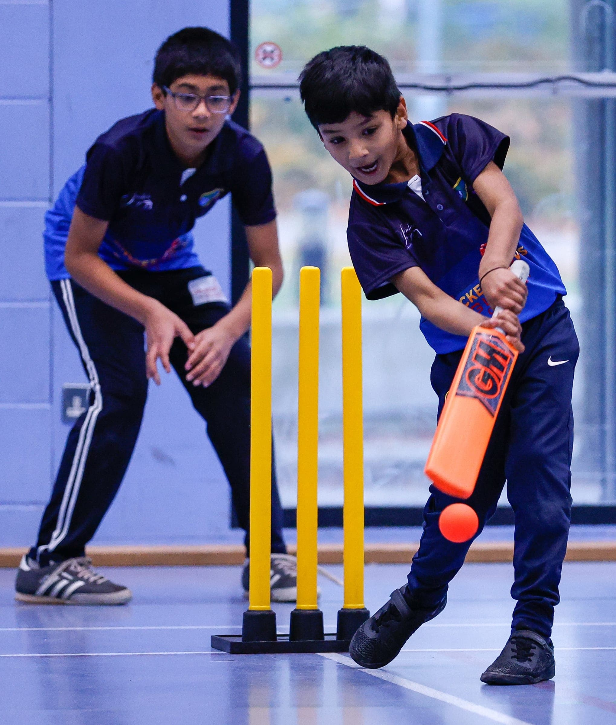 Players batting in an indoor academy session